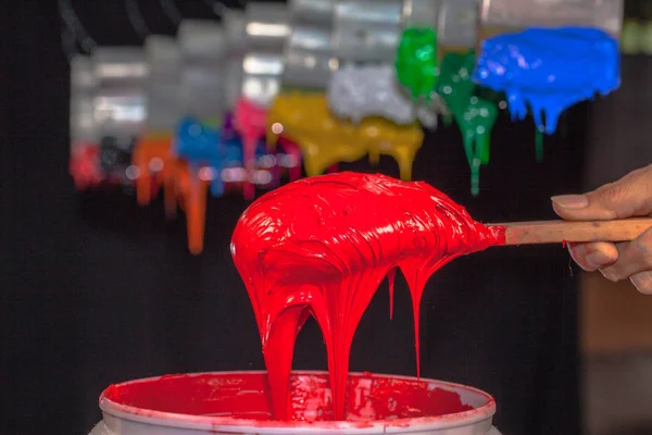 Red Plastisol ink on the wooden spoon in factory tee shirt — Stock Photo, Image