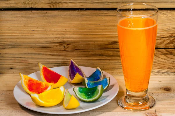 Orangensaft mit bunter Zitrone im Holzhintergrund — Stockfoto