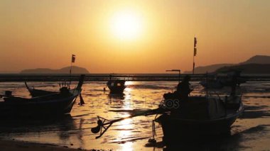 Rawai Körfezi'nde deniz manzaralı güzel sunshine. Kızıl gökyüzü için altın rengi değiştirme. Bir balıkçı teknesi ile kumlu bir plaj üzerinde güneşin yansıması demirleyen.