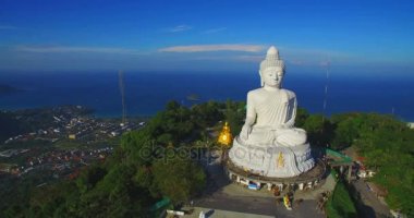 Phuket Big Buddha heykeli dağın tepesinde arkasında sahne mavi gökyüzü ve mavi okyanus vardır.