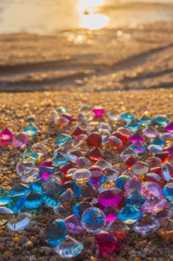sabah güneş ile renkli değerli taşlar üzerinde. değerli taşlar sahilde hakkında dağınık düşüyor.