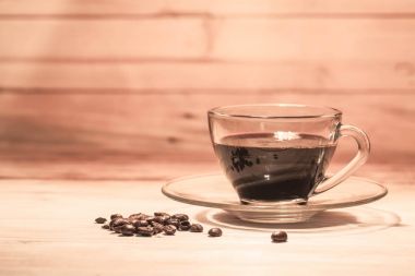 şeffaf kahve fincanı ve pinewood masada.