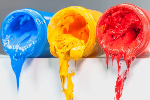 yellow blue and red colors of Plastisol ink on white table. Plastisol ink for print tee shirt and any fabric useful in tee shirt factory. yellow blue and red colors are primary color.