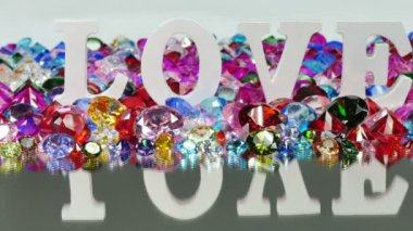 Beyaz kelime aşk renkli elmas ve gül alan üzerinde yer alır, kelime aşk aşk Sevgililer günü için.