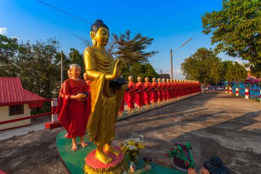 Sabah sadaka veren Buddha ve rahipler heykeli.