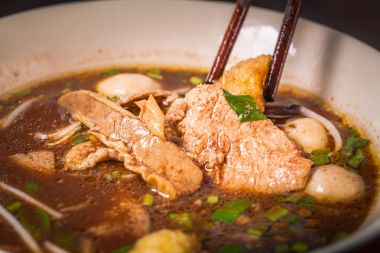 El çubuk toplama lezzetli makarna için siyah arka plan üzerine kullanır.