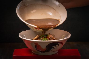 El çubuk toplama lezzetli makarna için siyah arka plan üzerine kullanır.