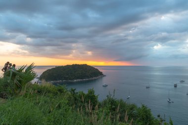 Promthep pelerini ve rüzgar türbini manzarasının önündeki adam adası. Promthep pelerini ve rüzgar türbini