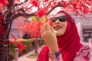 Güzel İslamcı bayan Bangkok 'taki merkez meydanında kırmızı Sakura ile eğleniyor.