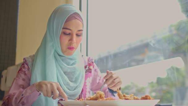 イスラム教徒の女性がバンコク市内の道路脇のレストランでフライドチキンを食べるタイ — ストック動画