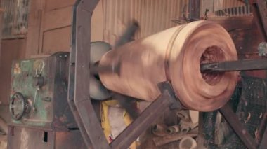 İşçiler dönen bir motor kullanarak ve keskin bir nesne kullanarak uzun davul oluşturuyorlar.