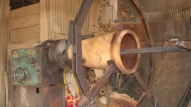 İşçiler dönen bir motor kullanarak ve keskin bir nesne kullanarak uzun davul oluşturuyorlar.