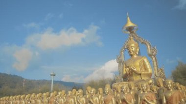 Nakornnayouk, Tayland 'daki Nakornnayouk' taki MAKHA BUDDHIST MEMORIAL PARK adlı kırsal kamu tapınağındaki küçük Buda heykelleri arasında büyük altın bir Buda heykeli.