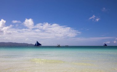 Filipinler 'deki Boracay adasında beyaz sahil ve mavi yelkenliler.