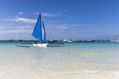 Filipinler 'deki Boracay adasında beyaz sahil ve mavi yelkenliler.