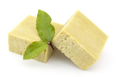 Beyaz arka planda taze defne yaprakları ve defne sabunu..