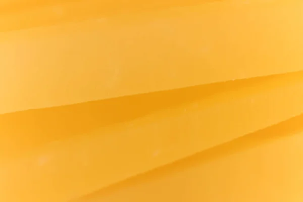 Solidní sýr plátky makro zblízka. Textura pozadí. — Stock fotografie