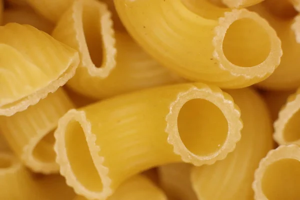 Italiaanse hoorns Pasta textuur. Macaroni ongekookt voedsel achtergrond. Macro close-up. — Stockfoto