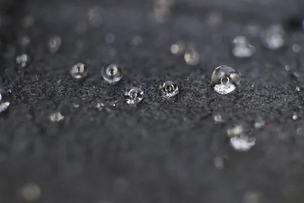 Pequenas gotas de água na textura de fundo de couro preto. Macro Closeup . — Fotografia de Stock