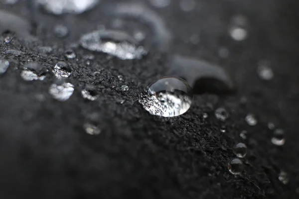 Kapky vody na texturu pozadí černé kůže. Detailní makro. — Stock fotografie