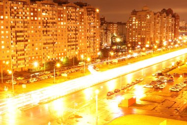 Gece Kavsagi yol pozlama manzara ışıklar. Arka plan üzerinde yaşayan binalar. Saint-Petersburg, Bogatirskiy avenu.