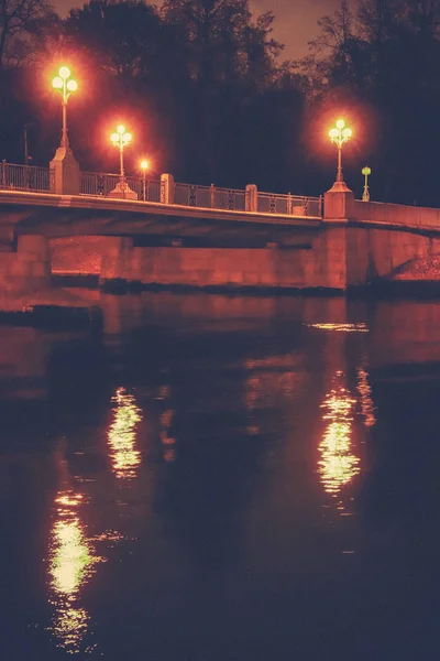 Νυχτερινή γέφυρα με φανάρια και η αντανάκλασή τους πάνω από τον ποταμό Νέβα — Φωτογραφία Αρχείου