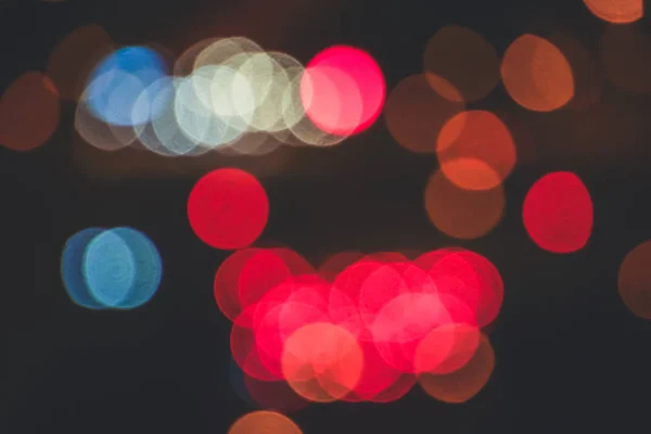 Unfocused evening lights. Red circles bokeh background. Blurred colored circles backdrop.