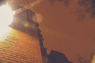 Fenerli tuğla bir evin arka planına kar yağıyor.