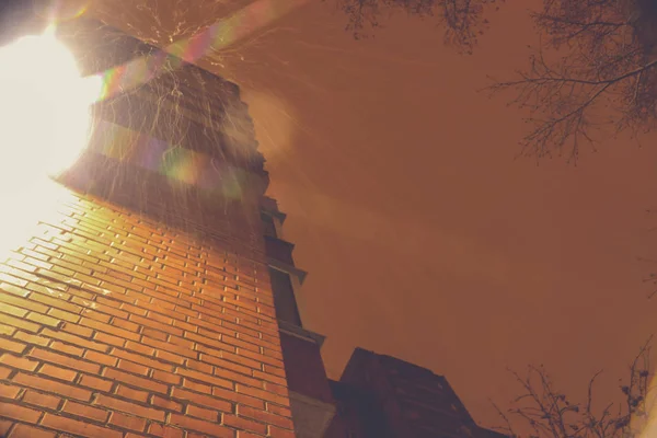 Falling snow on the background of a brick house with lantern — ストック写真