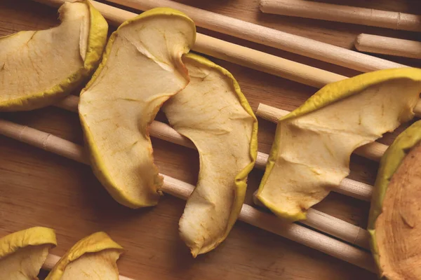 Apple slices are dried on wood sticks. Macro closeup.