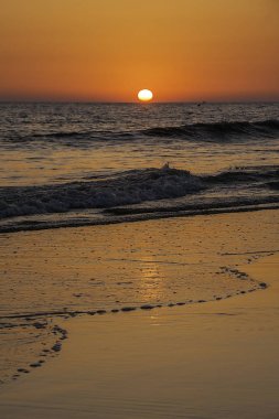 Turuncu baskın renk ile bir plaj güneş güzel koyarak