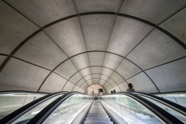 Yeraltına iniyor. Bir metro istasyonuna giden yürüyen merdivenler.