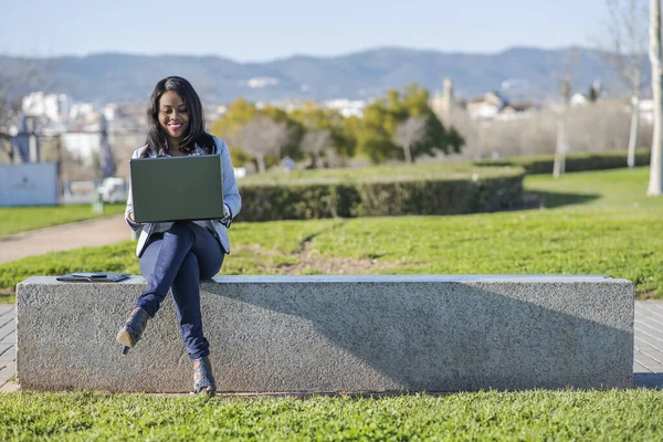 Afroameričanka používající notebook ve venkovním parku — Stock fotografie