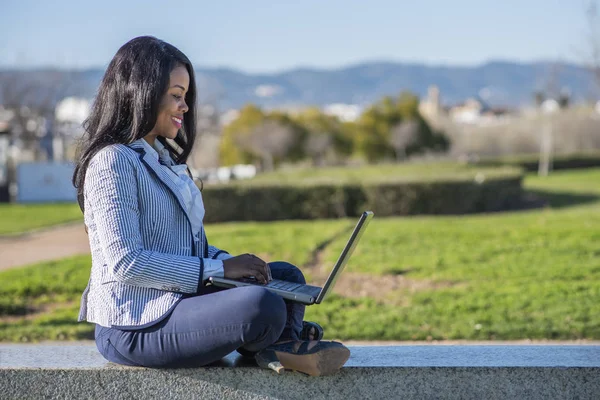 Afroameričanka používající notebook ve venkovním parku — Stock fotografie