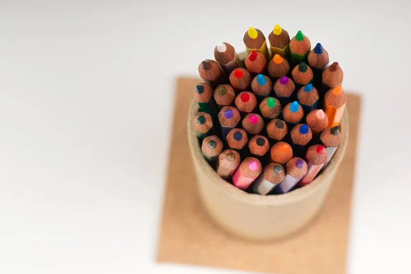 Multicolored pensils in the box on the white paper. — Stock Photo, Image