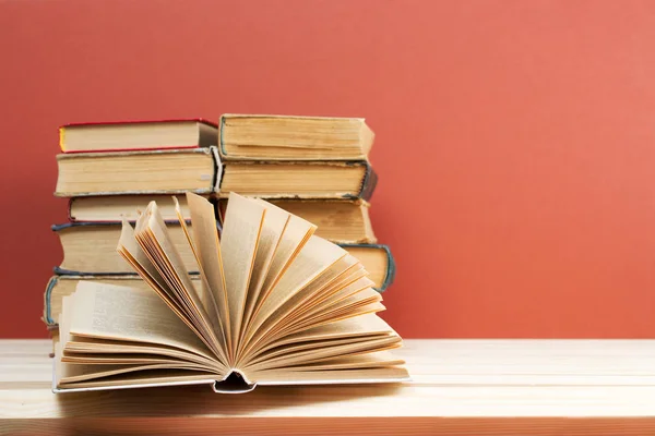 Libro abierto, pila de libros de tapa dura sobre mesa de madera . —  Fotos de Stock