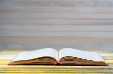 Tahta masanın üzerinde açık bir kitap.