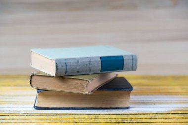 Ahşap masa üzerinde ciltli kitap yığını. Okula dönüş.