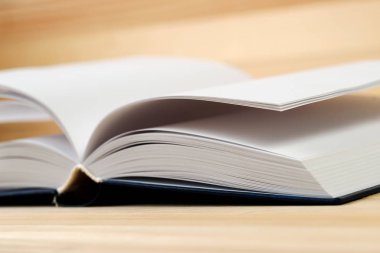 Tahta masanın üzerinde açık bir kitap.