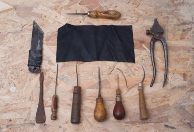 Deri el sanatları araçları ahşap arka plan üzerinde. Craftmans çalışma masası.