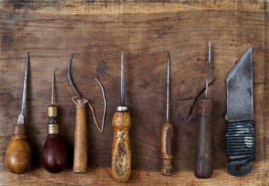 Deri el sanatları araçları ahşap arka plan üzerinde. Craftmans çalışma masası.