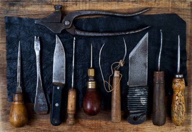 Deri el sanatları araçları ahşap arka plan üzerinde. Craftmans çalışma masası.