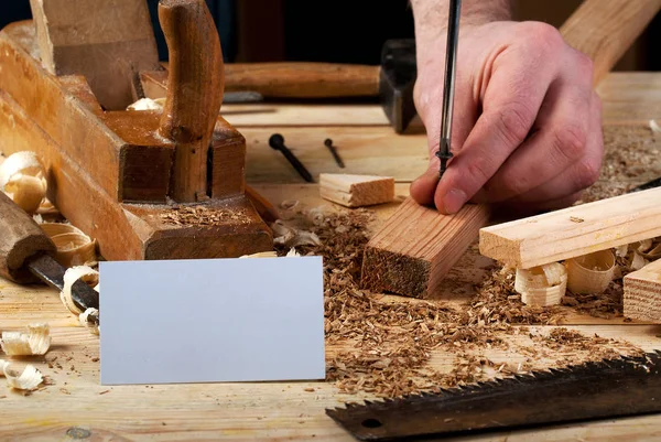 Visitekaartje op houten tafel voor timmerman tools met zaagsel. — Stockfoto