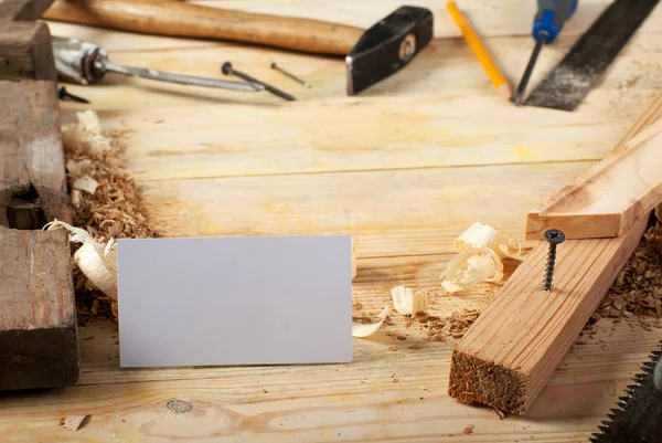 Visitekaartje op houten tafel voor timmerman tools met zaagsel. — Stockfoto