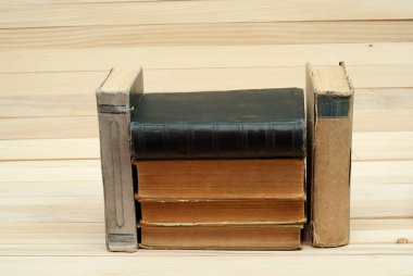 Ahşap masa üzerinde ciltli kitap yığını. Okula dönüş.