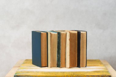 Ahşap masa üzerinde ciltli kitap yığını. Okula dönüş.