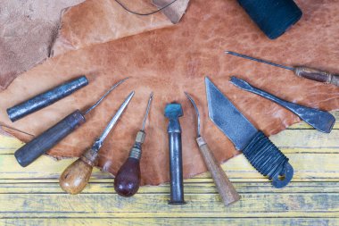 Deri el sanatları araçları ahşap arka plan üzerinde. Deri craftmans çalışma masası. Çalışma tablosu gizle ve çalışma el yapımı araçları parçası