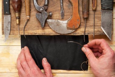 Deri el sanatları araçları ahşap arka plan üzerinde. Craftmans işçiliği DIY araçları kullanarak deri ile çalışma. Çalışma tablosu gizle ve çalışma el yapımı araçları parçası. Üstten Görünüm