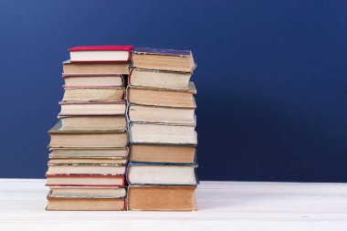 Ahşap masa üzerinde ciltli kitap yığını. Okula dönüş.