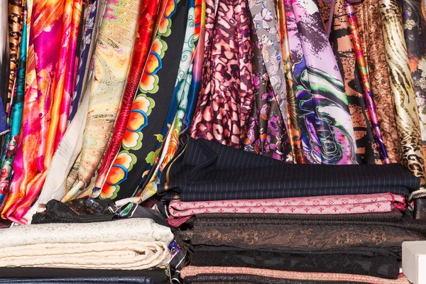 Rollen van textiel, doek en weefsel van verschillende kleuren op de markt. Winkelen op de verkoop van stoffen. Kopiëren van ruimte — Stockfoto